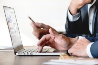 Professionista che confronta diversi strumenti digitali sul laptop per scegliere quello più adatto al proprio lavoro