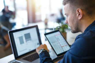 Professionista che testa un nuovo software AI sul laptop durante una settimana di lavoro organizzato