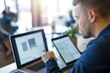 Professionista che testa un nuovo software AI sul laptop durante una settimana di lavoro organizzato